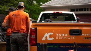 Two AC Yard Services employees next to an ACYS truck