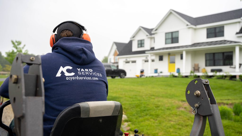 An AC Yard Services employee mowing a client's lawn